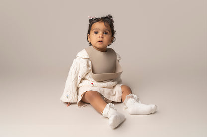 A silicone waterproof, easy-to-clean weaning bib with a catch-all pocket, designed to keep your baby's clothes clean during mealtimes. Features adjustable neck closures for a secure fit, making it suitable for babies and toddlers of all sizes. An essential item for weaning. BPA and phthalate-free, with unbreakable construction, safe for microwave and dishwasher use.