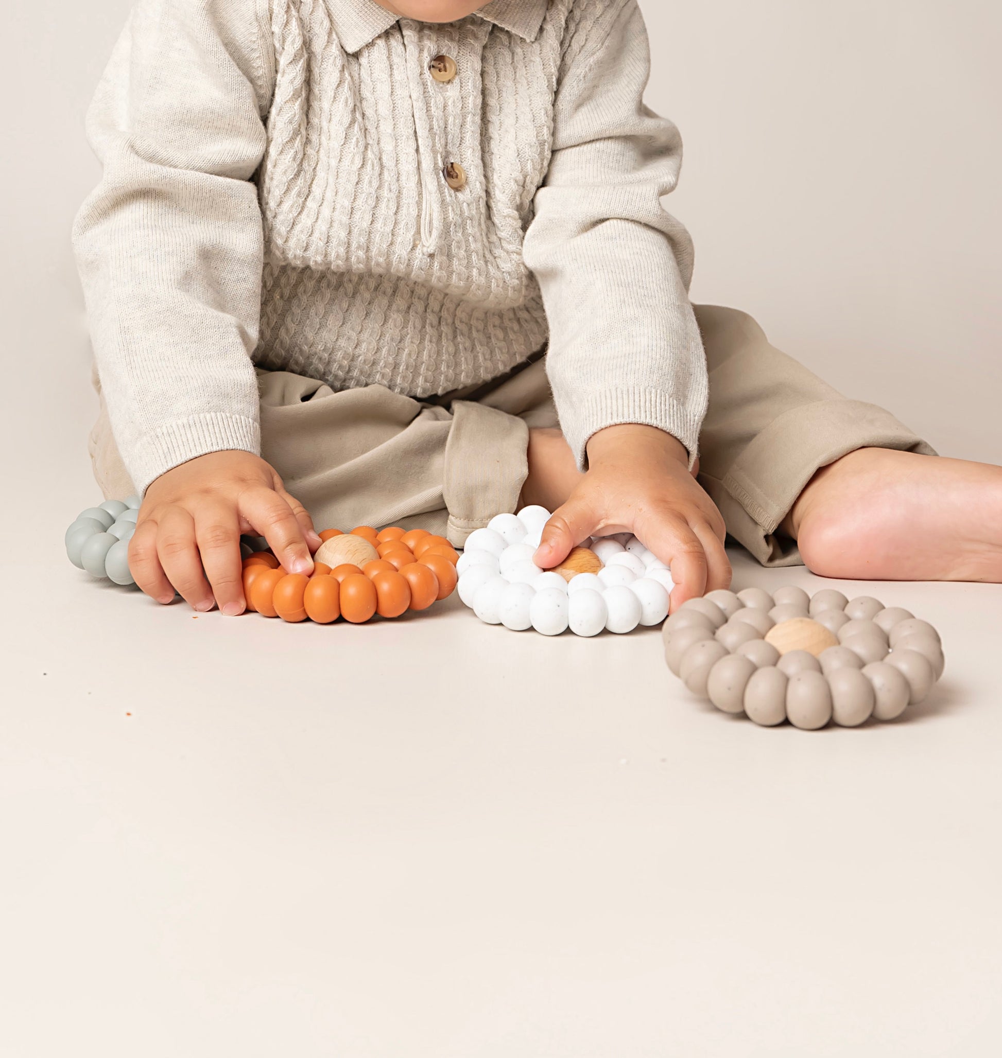A Teething toy for babies made up of many large silicone beads to mimic a flower. A stylish and soothing solution for infants. Available in 4 colours, it is carefully crafted with premium food-grade silicone for safety and durability.