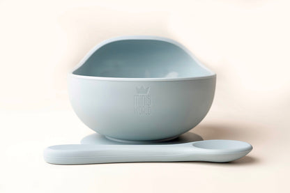 A baby weaning Suction Bowl + Spoon Set designed to make weaning easier and help babies and toddlers establish mealtime independence. The set features a raised side to assist child in scooping up food independently. It has a strong suction base to prevent spills and overturned bowls. Made from BPA and Phthalate-free, non-toxic food-grade silicone, it is unbreakable, waterproof, and easy to clean. Microwave and dishwasher safe.
