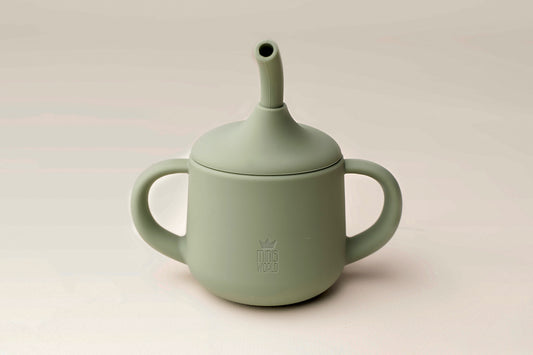 A versatile cup designed to adapt to your Mini's developmental stage and preference, featuring options for a straw, spout, and open tumbler. Twin handles provide a secure grip, promoting spill-proof and confident independent drinking. BPA and phthalate-free, made from non-toxic food-grade silicone, with unbreakable construction, waterproof, easy to clean, and safe for microwave and dishwasher use."